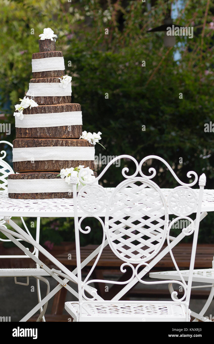 Una torta di nozze realizzati in legno e decorate con eleganti fiori bianchi. Foto Stock