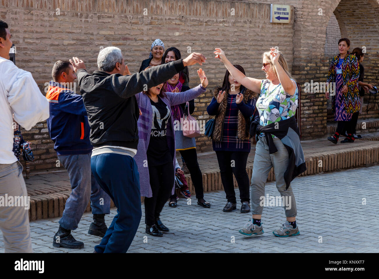 I turisti si uniscono in un matrimonio da ballare con la gente del posto in strada, Khiva, Uzbekistan Foto Stock I turisti si uniscono in un matrimonio da ballare con la gente del posto in strada, Khiva, Uzbekistan Foto Stock