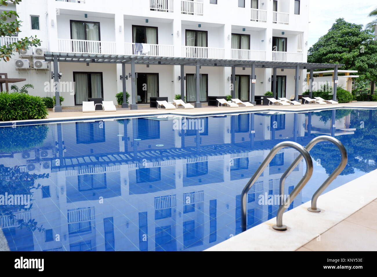 Hotel bello, appoggio e sedie blu piscina Foto Stock