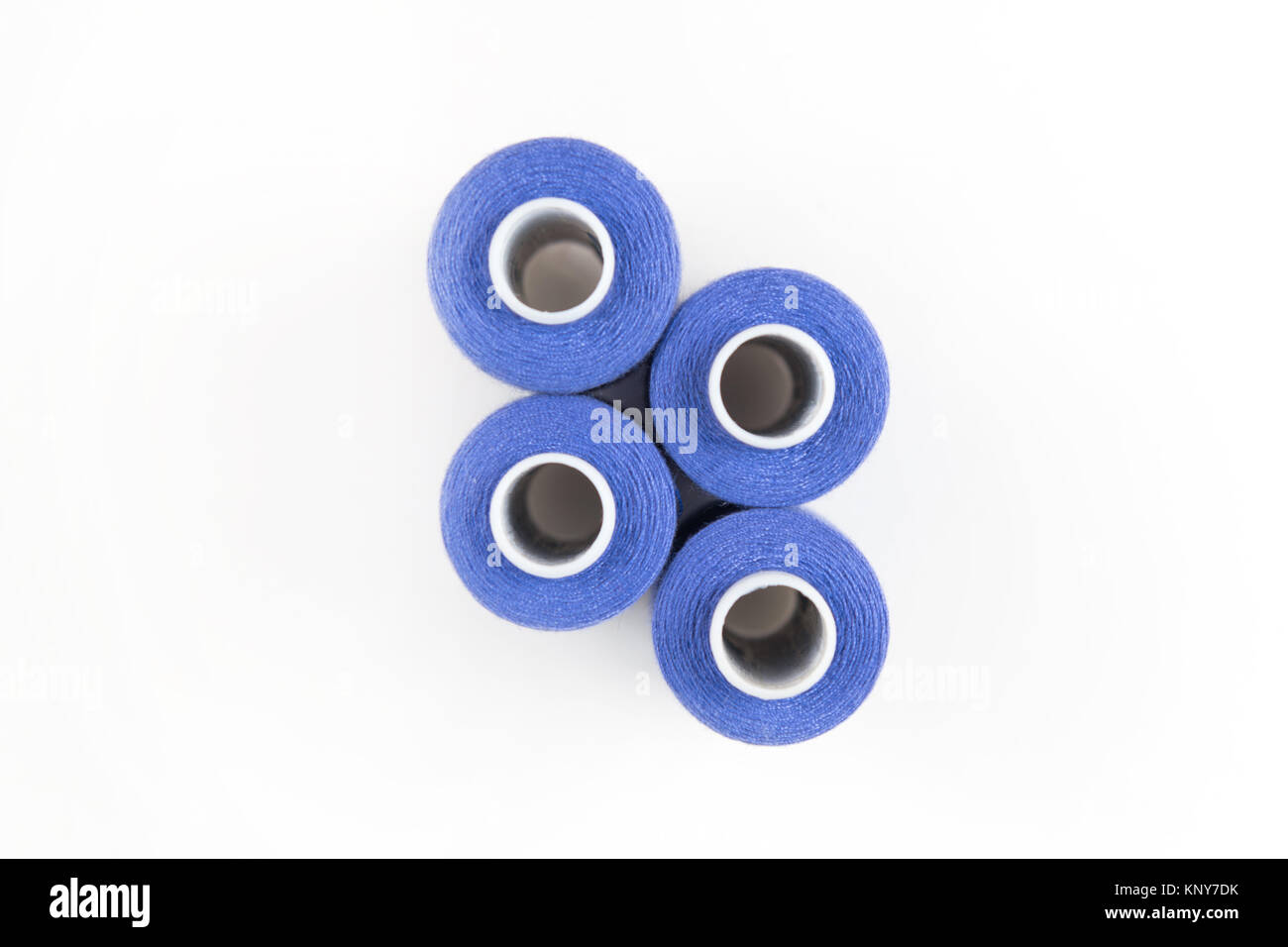 Viola quattro fili di cucitura su una bobine di bianco su uno sfondo bianco. Forniture di cucitura Foto Stock