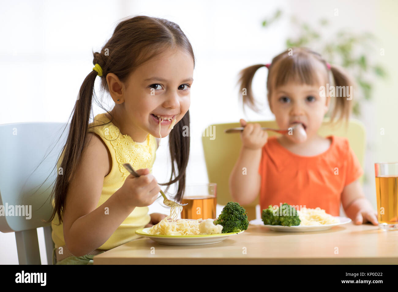 I bambini a mangiare cibo sano in vivaio o a casa Foto Stock