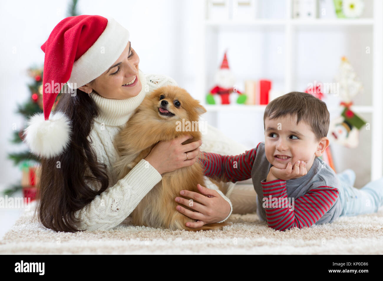 Felice capretto piccolo ragazzo, madre e cane a Natale Foto Stock