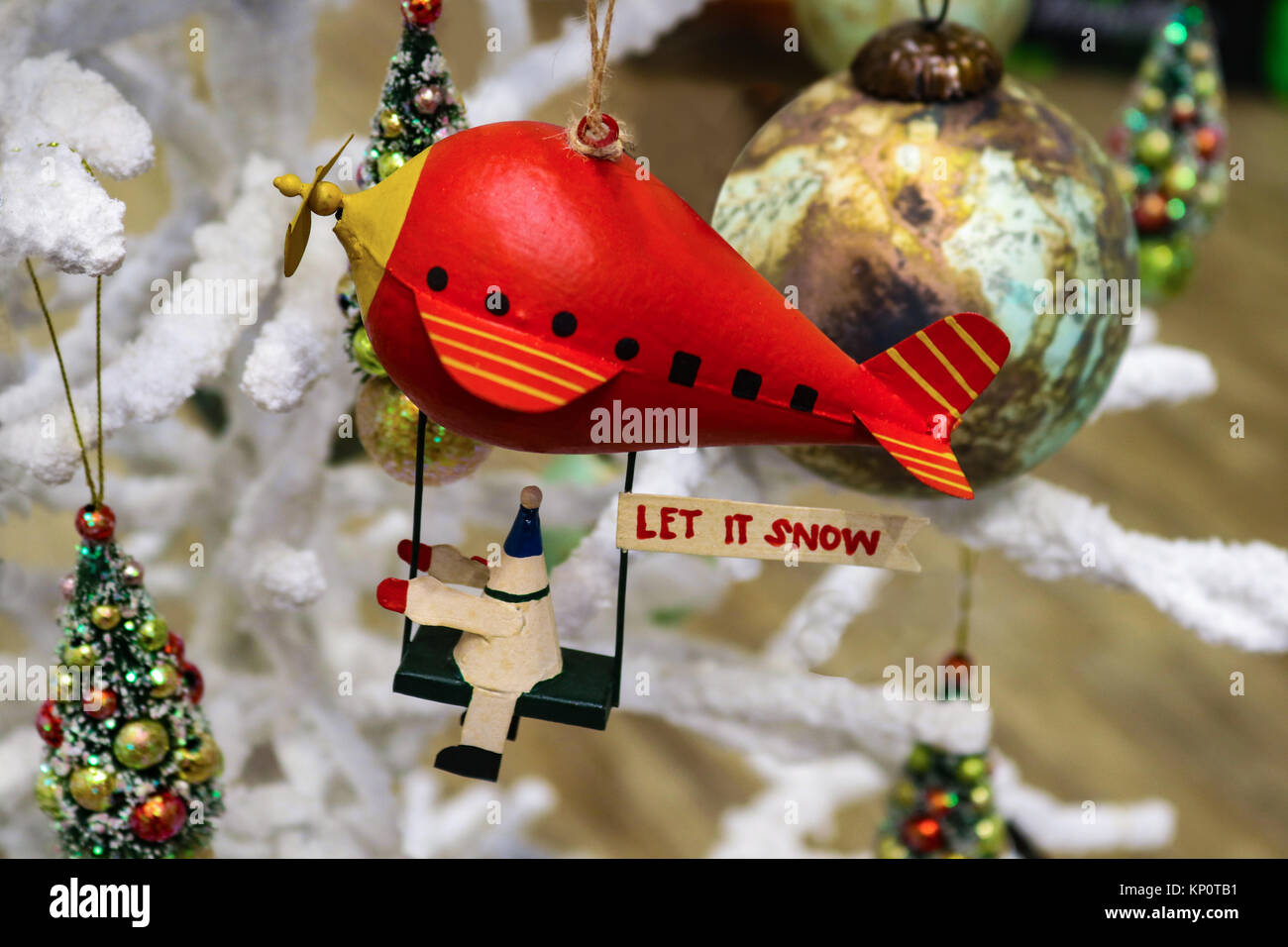 Natale robot a cavallo rosso blimp con Let it Snow segno su soffici albero di Natale con altri ornamenti Foto Stock