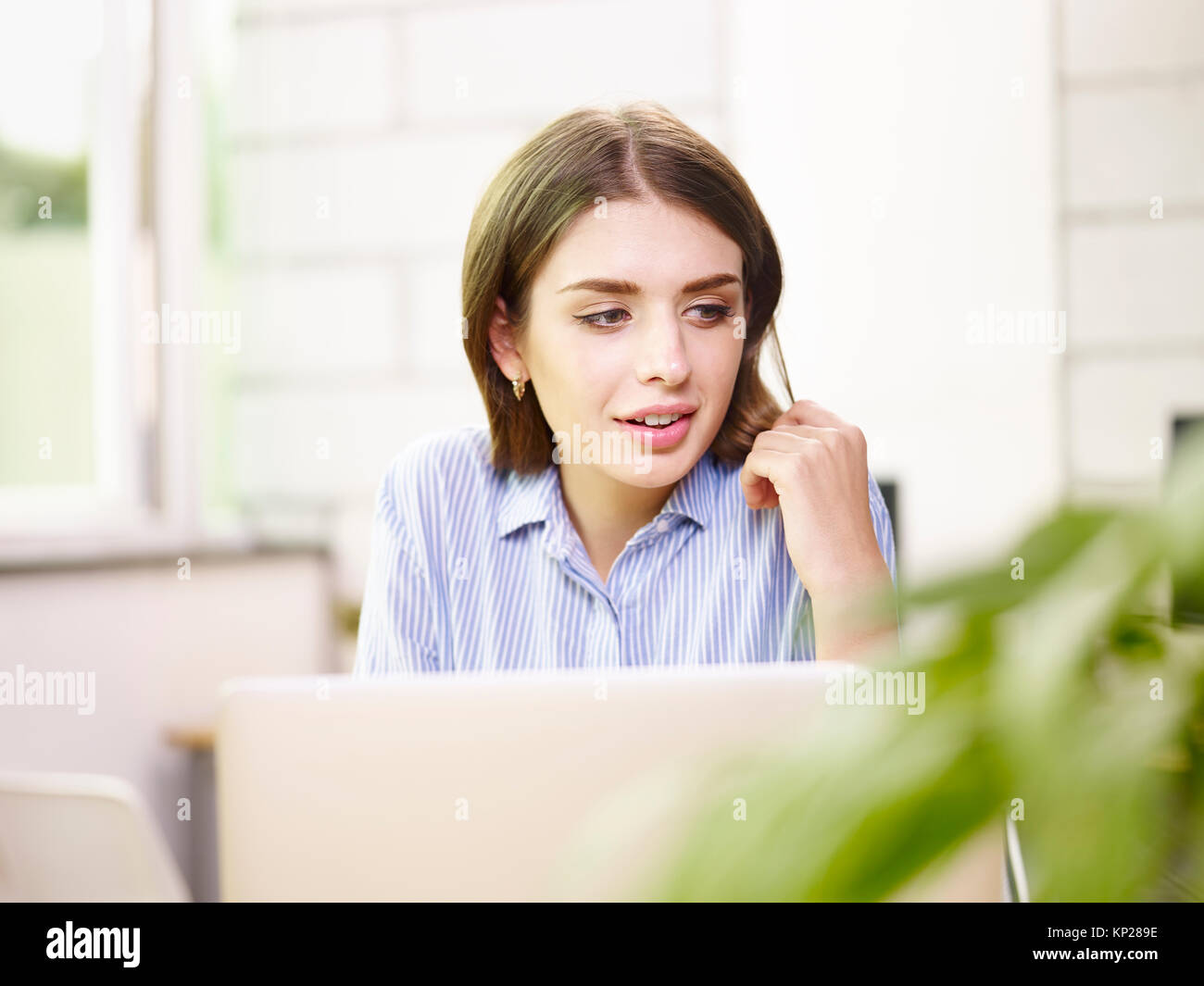 Giovane e bella caucasian business donna lavora in ufficio utilizzando il computer portatile. Foto Stock