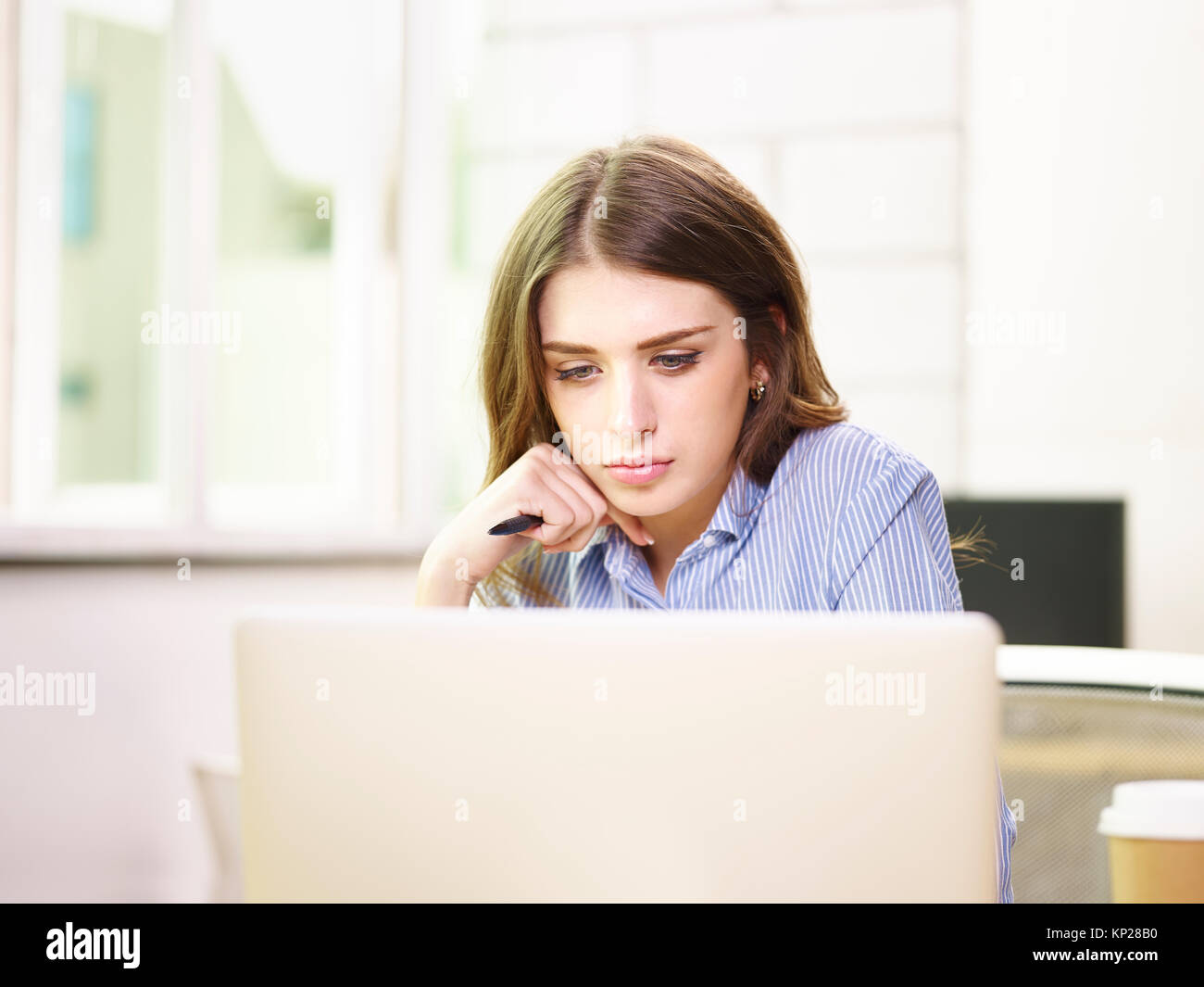 Giovane e bella caucasian business donna lavora in ufficio utilizzando il computer portatile. Foto Stock