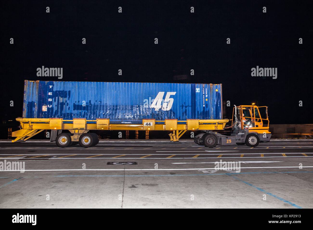 Carrello merci il trasporto di un contenitore blu di merci a Santa Cruz de Tenerife dock di notte Foto Stock