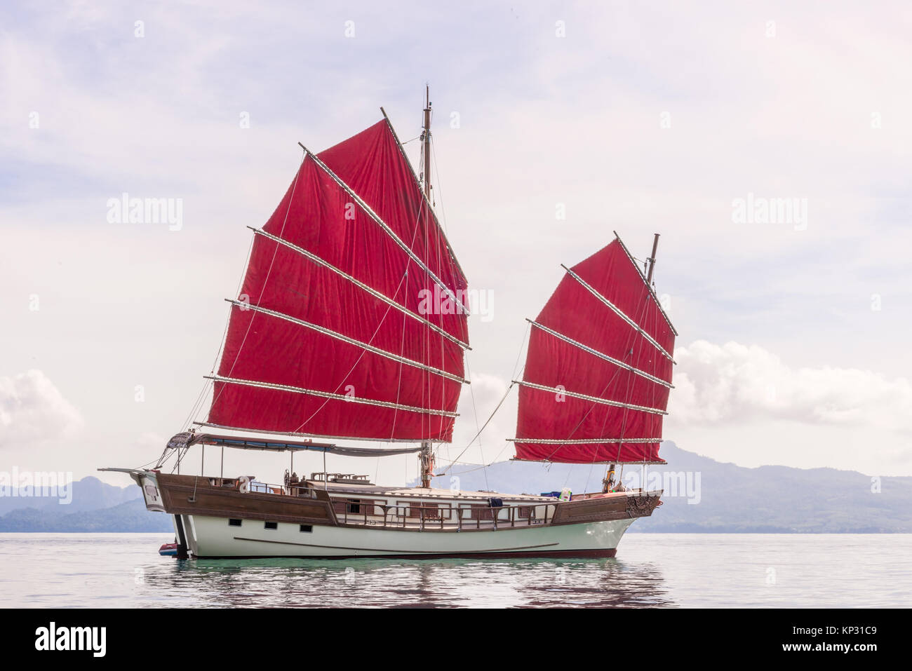 Un autentico yacht con red vele in mare contro lo sfondo delle montagne Foto Stock