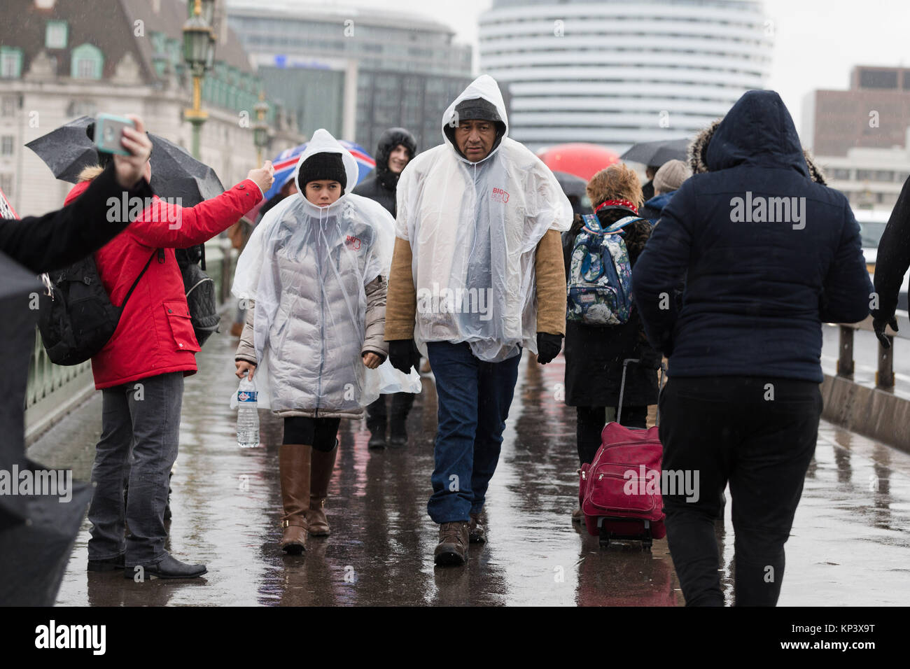 Londra, Regno Unito. Il 13 dicembre 2017. I turisti che indossa la pioggia poncho ombrelloni a piedi sotto la pioggia sul Westminster Bridge. Credito: Vickie Flores/Alamy Live News Foto Stock