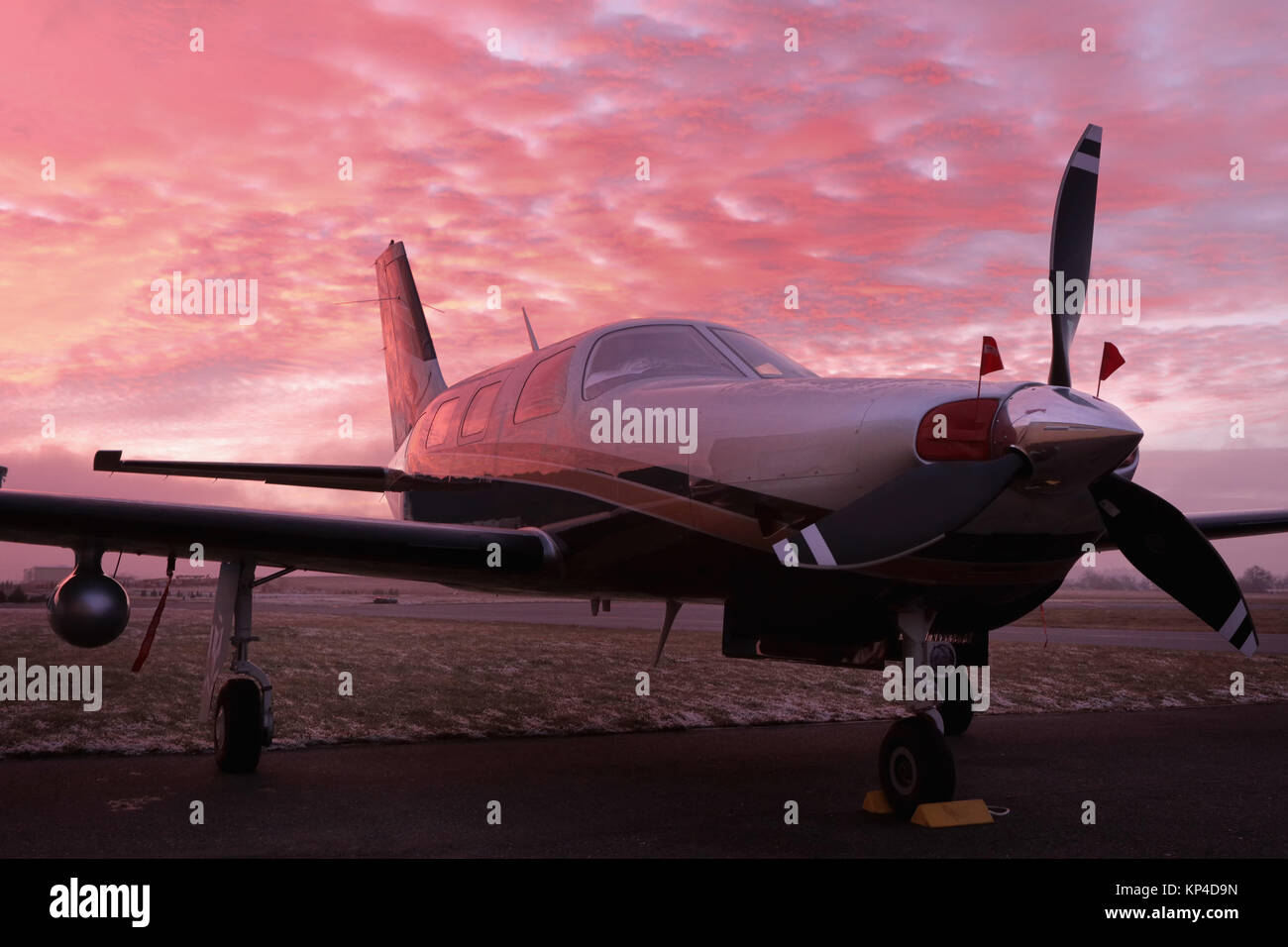 Piccolo parcheggio privato a singolo pistone per motore aereo sulla pista, piccola elica piano. Aerei a pistoni in aeroporto e splendidamente colorata durante le ore d'oro Foto Stock