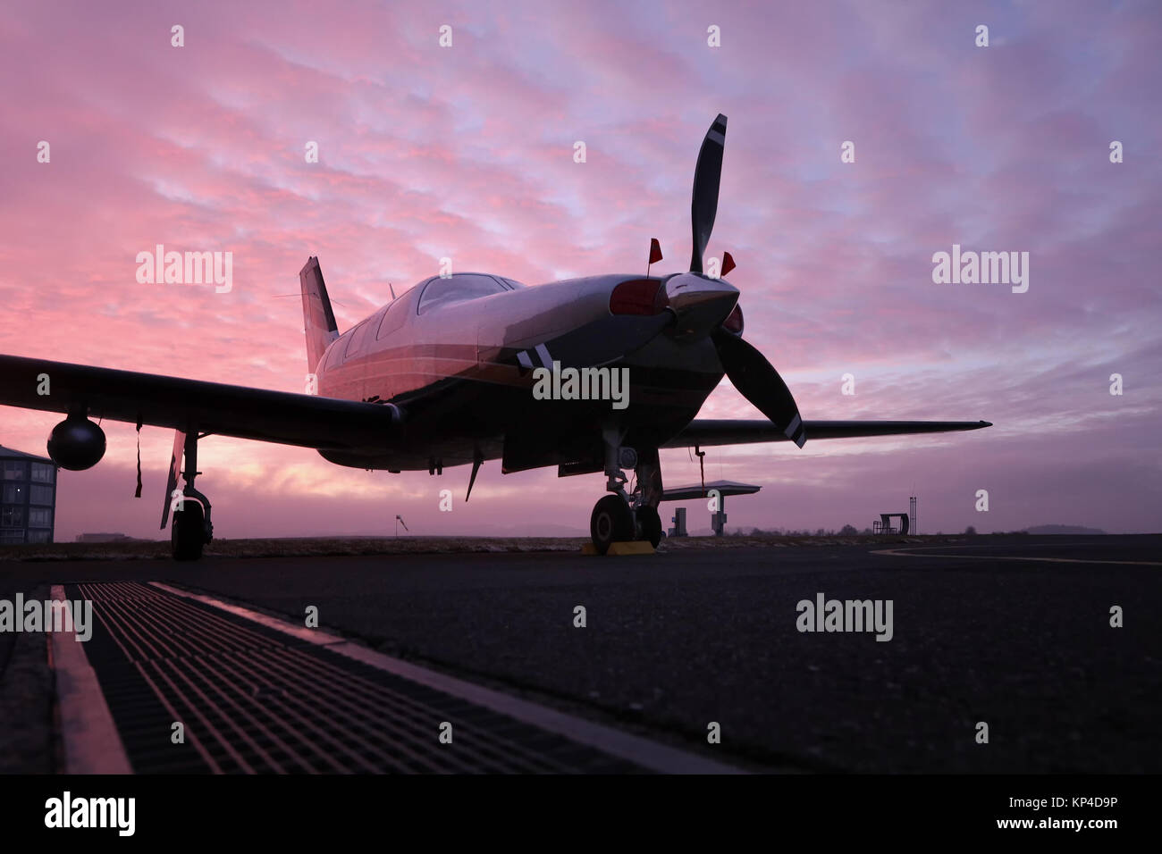 Piccolo parcheggio privato a singolo pistone per motore aereo sulla pista, piccola elica piano. Aerei a pistoni in aeroporto e splendidamente colorata durante le ore d'oro Foto Stock