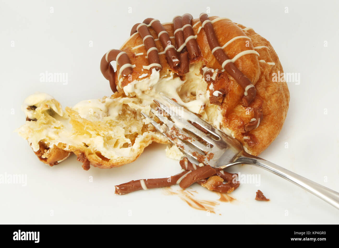 Il cioccolato belga choux bun con panna e una forcella su una piastra Foto Stock