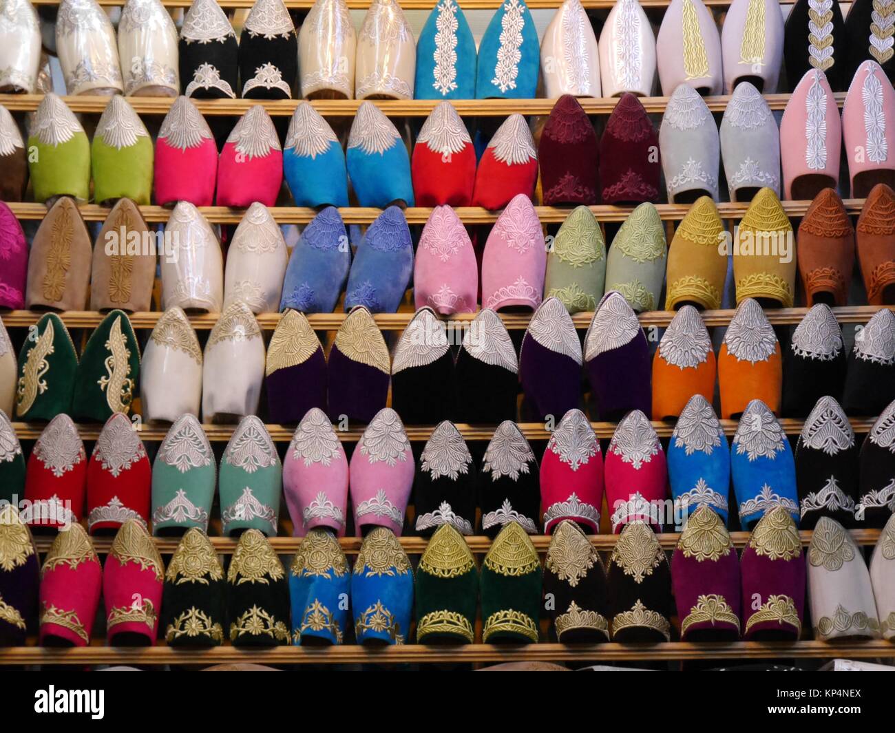 Chiusura del file di babouches scarpe in diversi colori sul display in una fase di stallo nel souk di Fez, Marocco Foto Stock