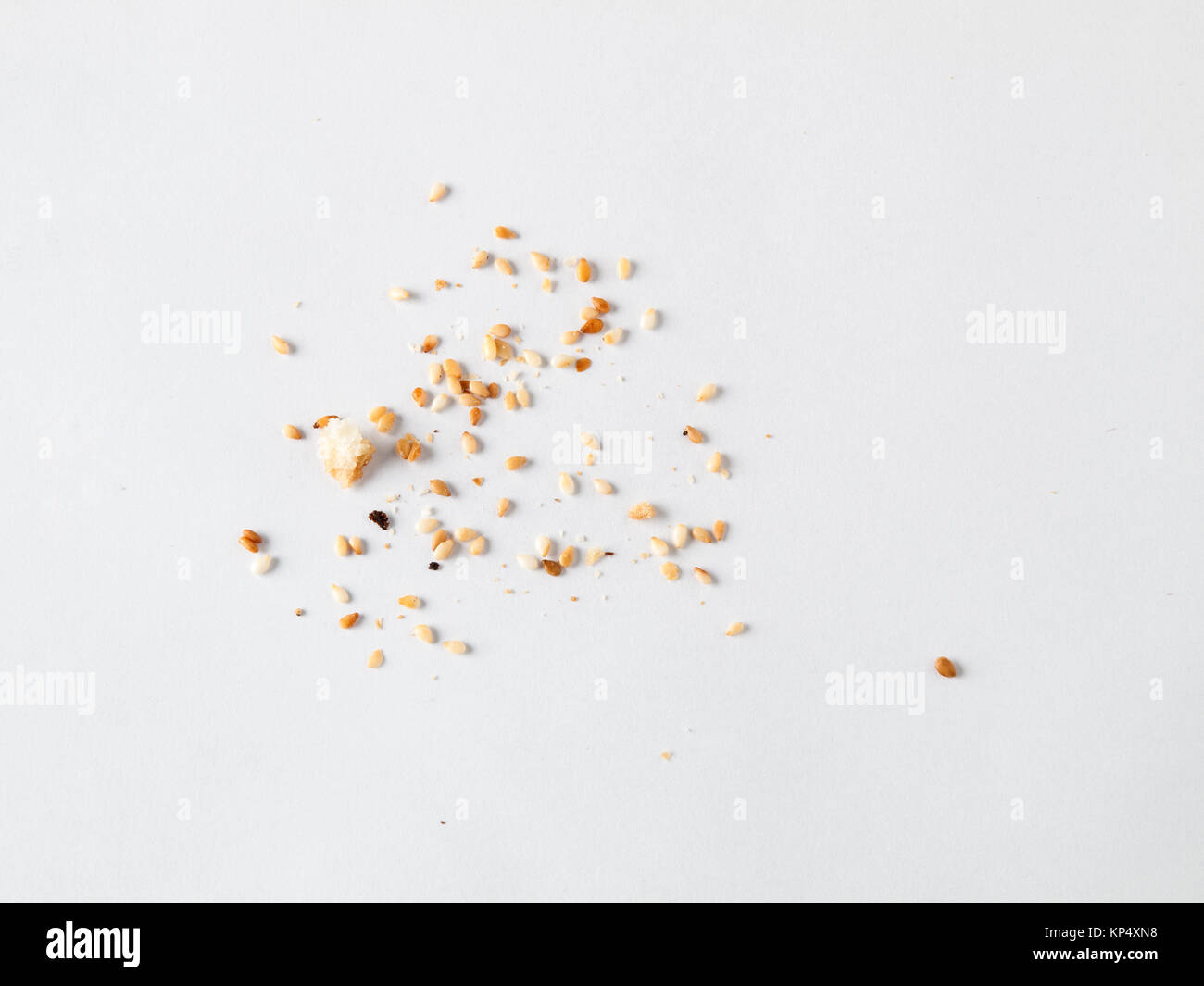 Sparse i semi di sesamo e briciole isolati su sfondo bianco Foto Stock