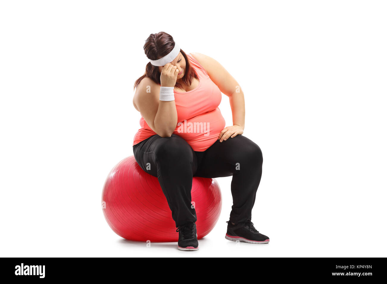 Triste sovrappeso donna seduta su una palla ginnica isolati su sfondo bianco Foto Stock