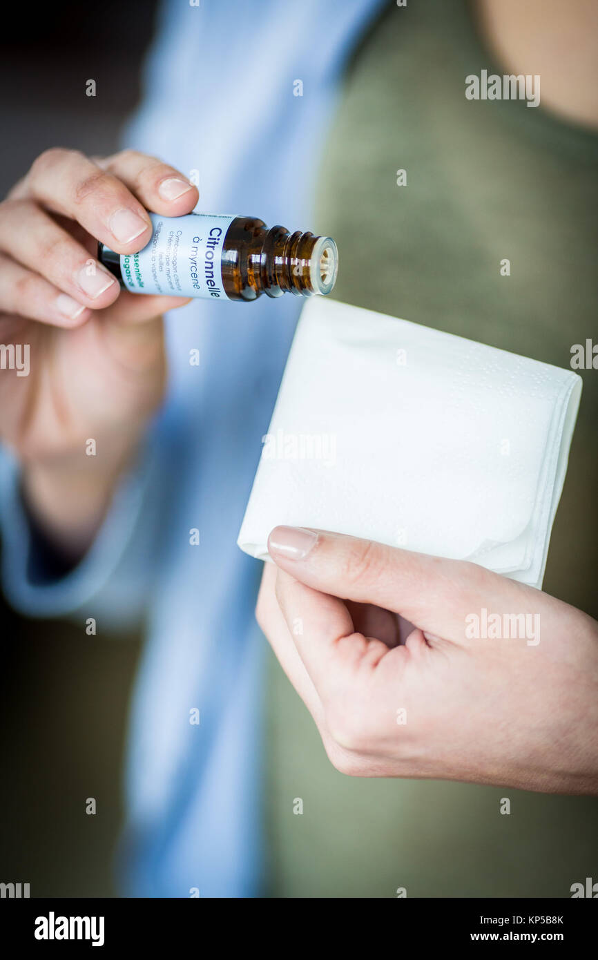 Donna di applicare alla citronella Olio essenziale su un tessuto. Foto Stock