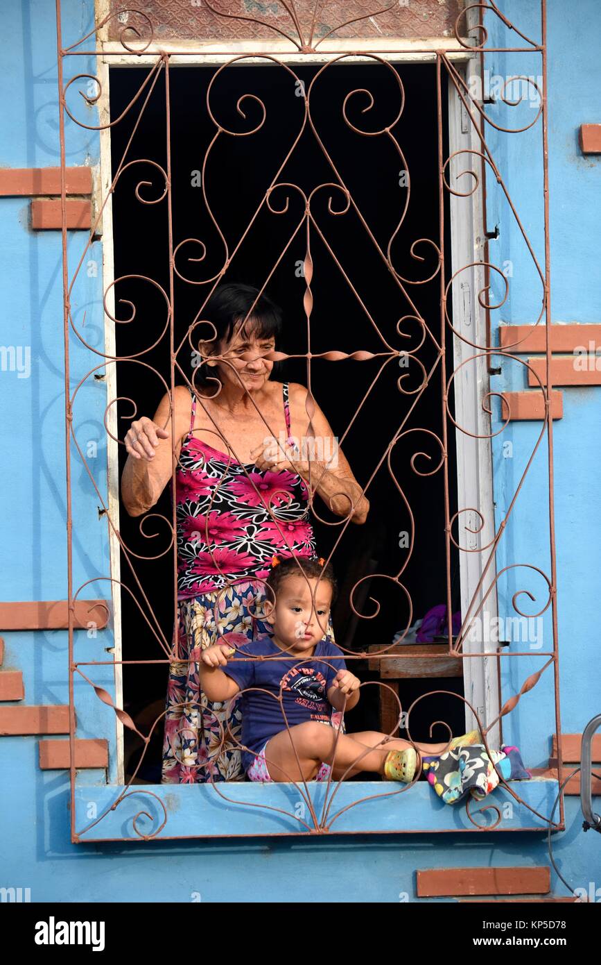 La madre e il bambino nella finestra Visualizzazione street, Trinidad, Cuba. Foto Stock