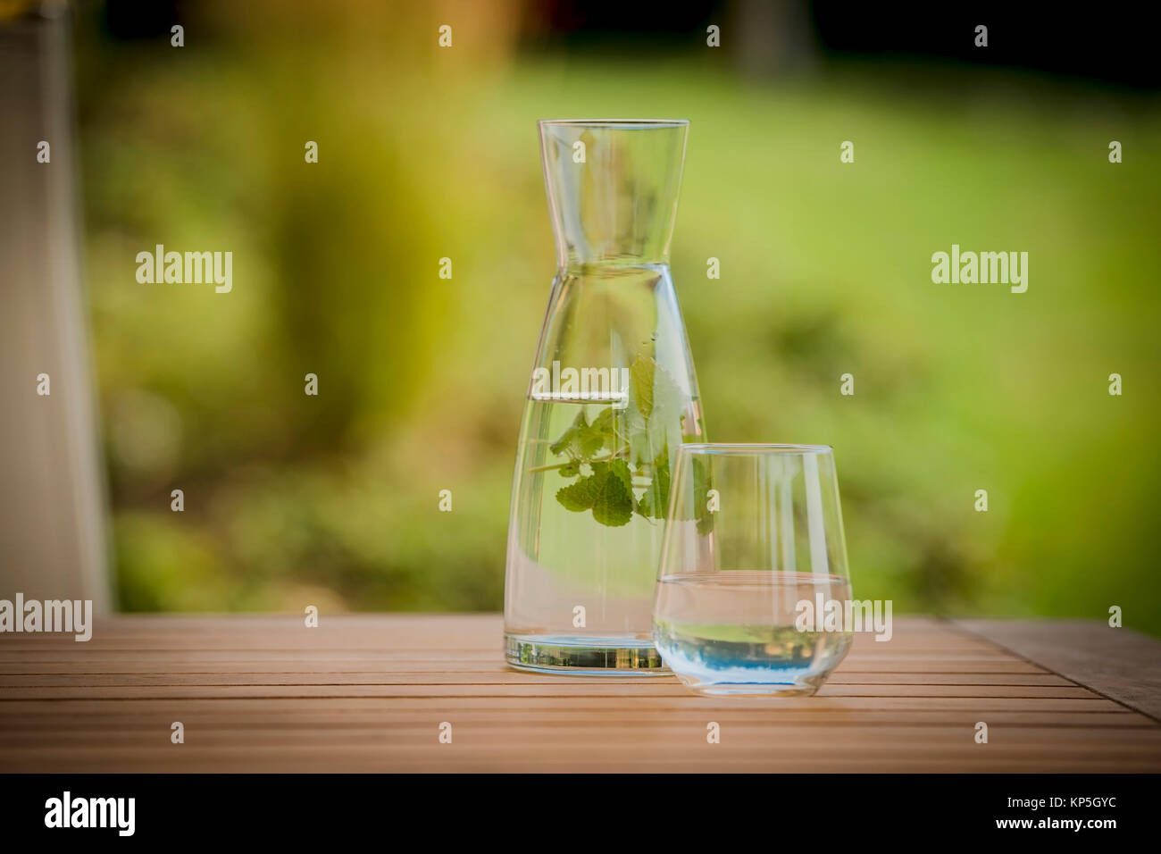 Wasserkrug- und glas mit Kraeutern - acqua Vaso con erbe aromatiche Foto Stock
