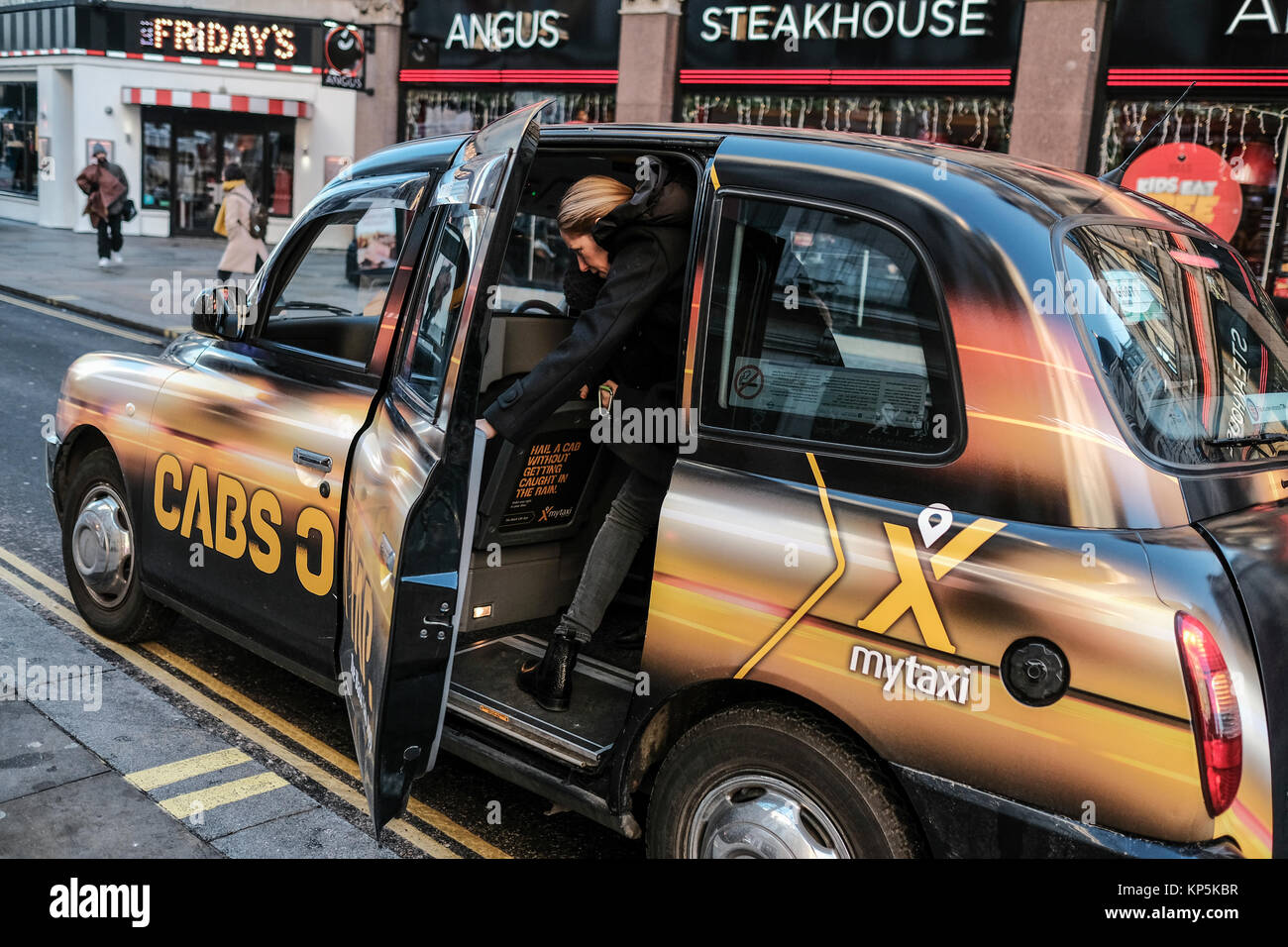 Una donna esce a Londra il Taxi in Leicester Square London REGNO UNITO Foto Stock