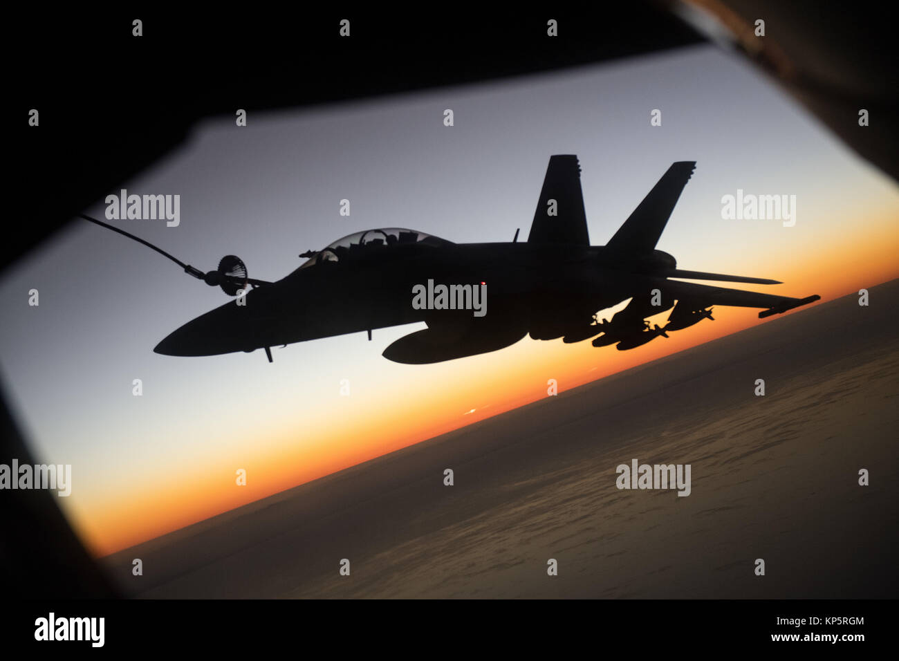 Un U.S. Air Force KC-135 Stratotanker antenna aerei di rifornimento refuels U.S. Navy F-18 Super Hornet jet da combattimento aereo durante un volo al tramonto del 7 dicembre 2017 sull'Afghanistan. (Foto di Jeff Morbo di Parkinson attraverso Planetpix) Foto Stock