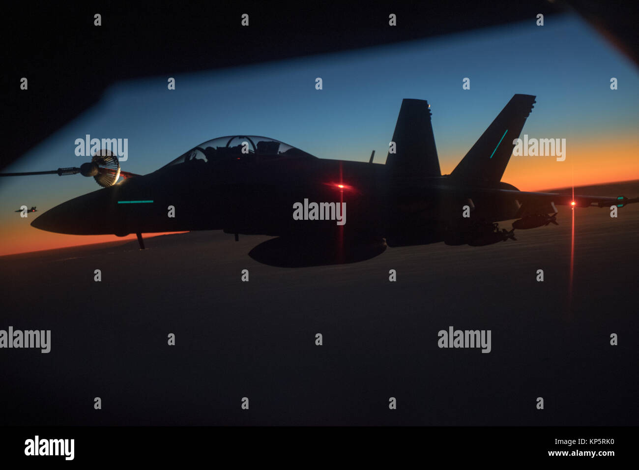 Un U.S. Air Force KC-135 Stratotanker antenna aerei di rifornimento refuels U.S. Navy F-18 Super Hornet jet da combattimento aereo durante un volo al tramonto del 7 dicembre 2017 sull'Afghanistan. (Foto di Jeff Morbo di Parkinson attraverso Planetpix) Foto Stock