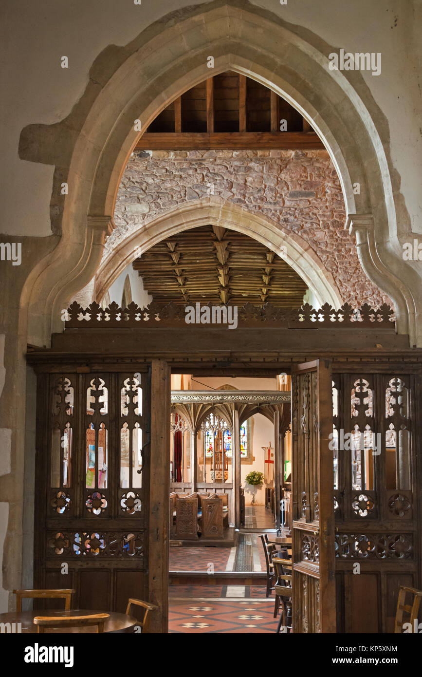 Ornati di schermi in legno e archi in pietra e le finestre di vetro macchiate all interno della chiesa di San Giorgio al Dunster, Somerset, Inghilterra Foto Stock