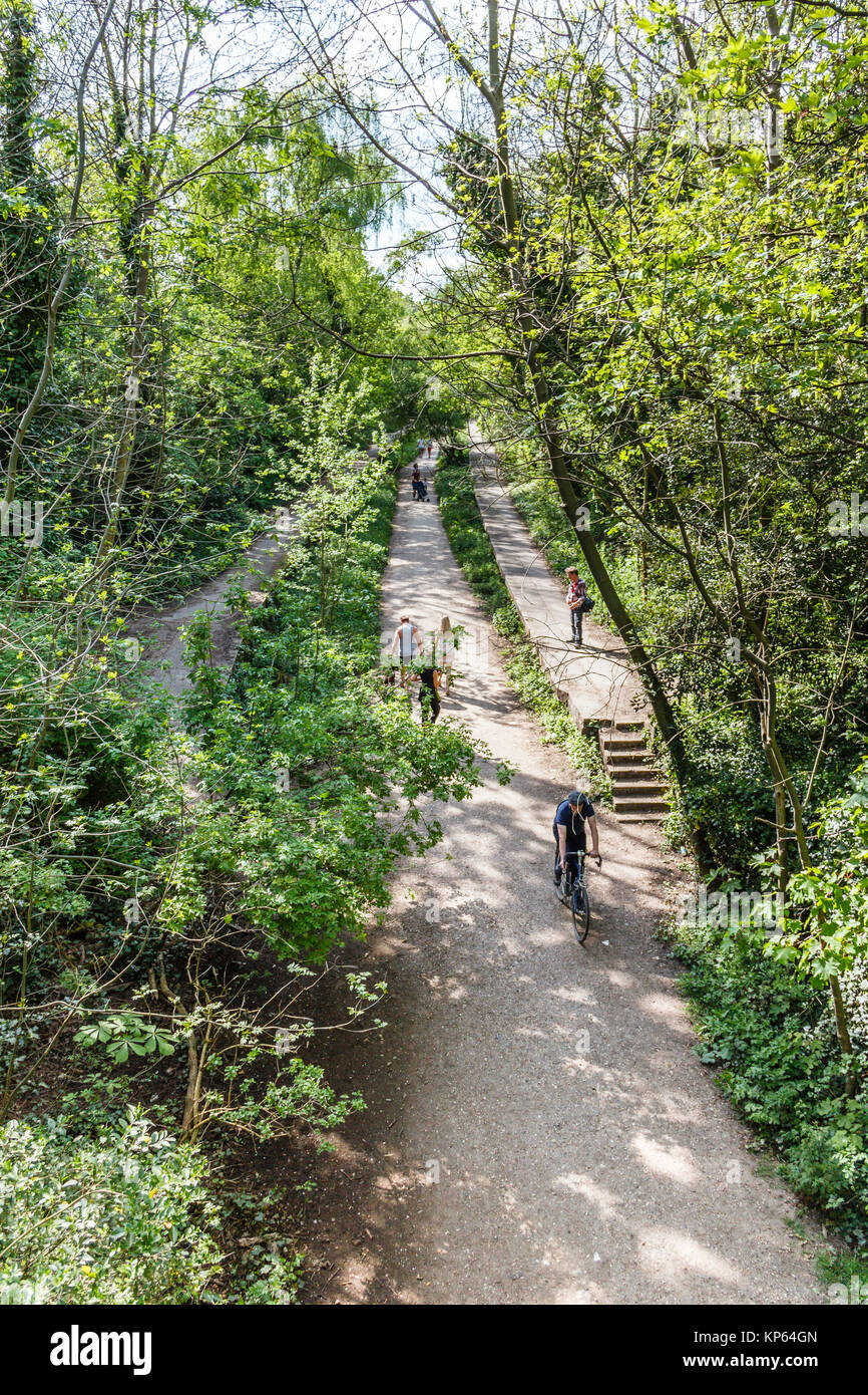 Camminatori e ciclisti sul Parco a piedi, una in disuso la linea ferroviaria, ora una zona di conservazione, a nord di Londra, Regno Unito Foto Stock