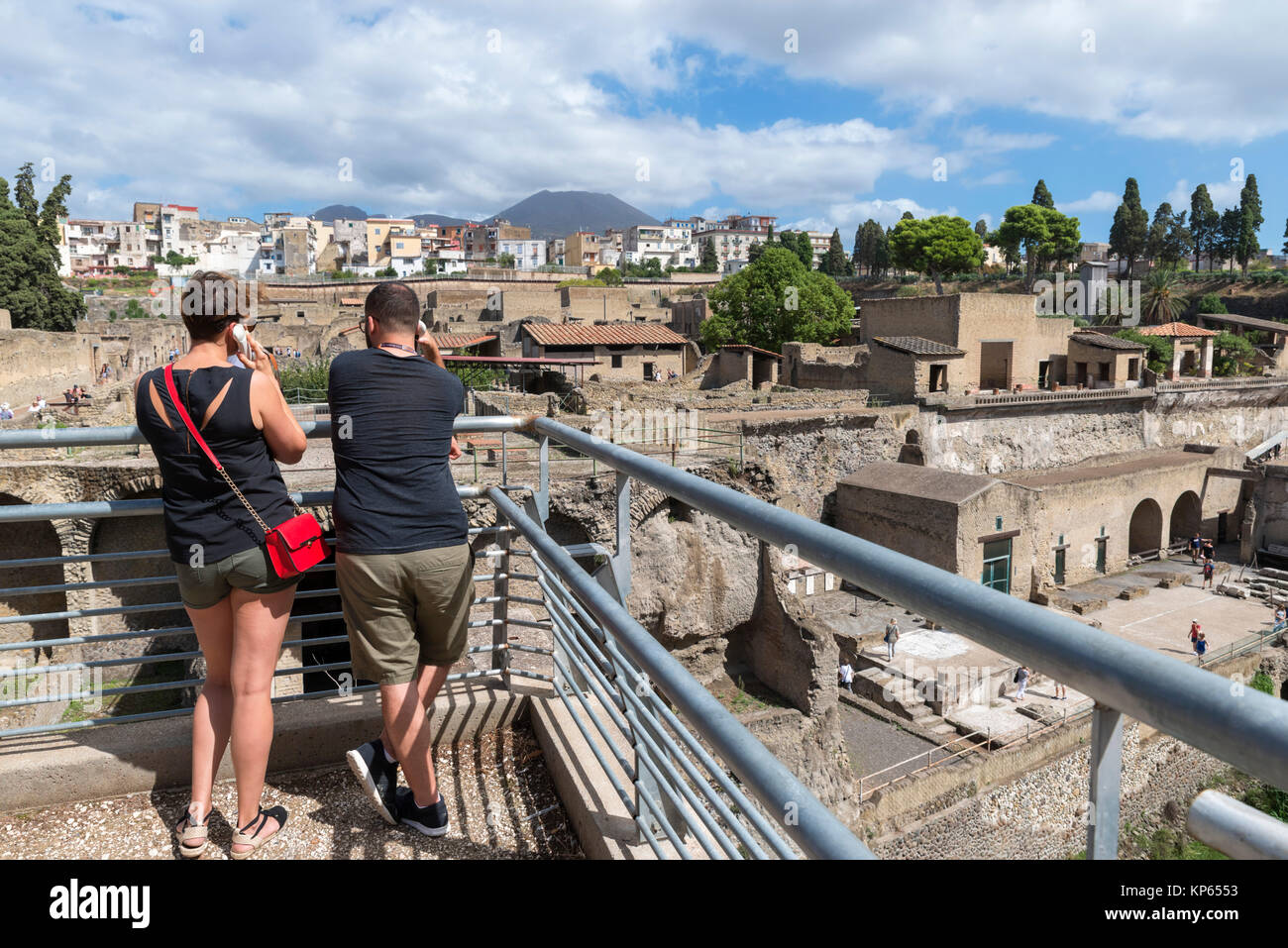 Giovane ascoltando l'audio guida a Ercolano (Ercolano) con vista verso il Vesuvio sullo sfondo, Napoli, campania, Italy Foto Stock