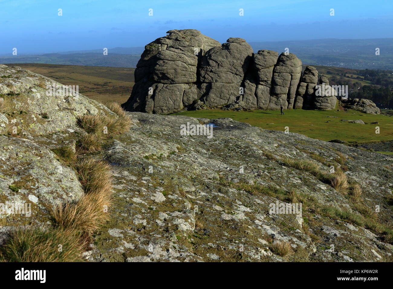 Guardando oltre il granito affioramento di Haytor verso la sua più grande sperone orientale con un passaggio di walker. Parco Nazionale di Dartmoor, Devon, Regno Unito. Dic 2017. Foto Stock