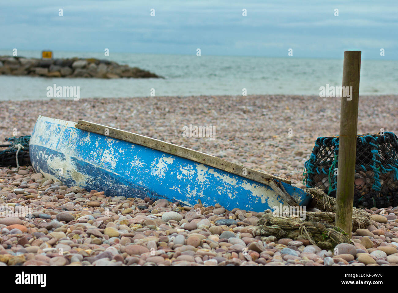 Vecchia barca si trovano su una spiaggia a Sidmouth, nel Devon, in Inghilterra che è sepolto nelle rocce Foto Stock