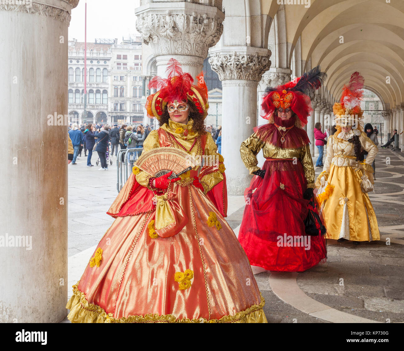 Il Carnevale di Venezia 2017, Veneto, Italia tre donne in costumi classic in posa al palazzo ducale di Piazza San Marco sotto gli archi Foto Stock