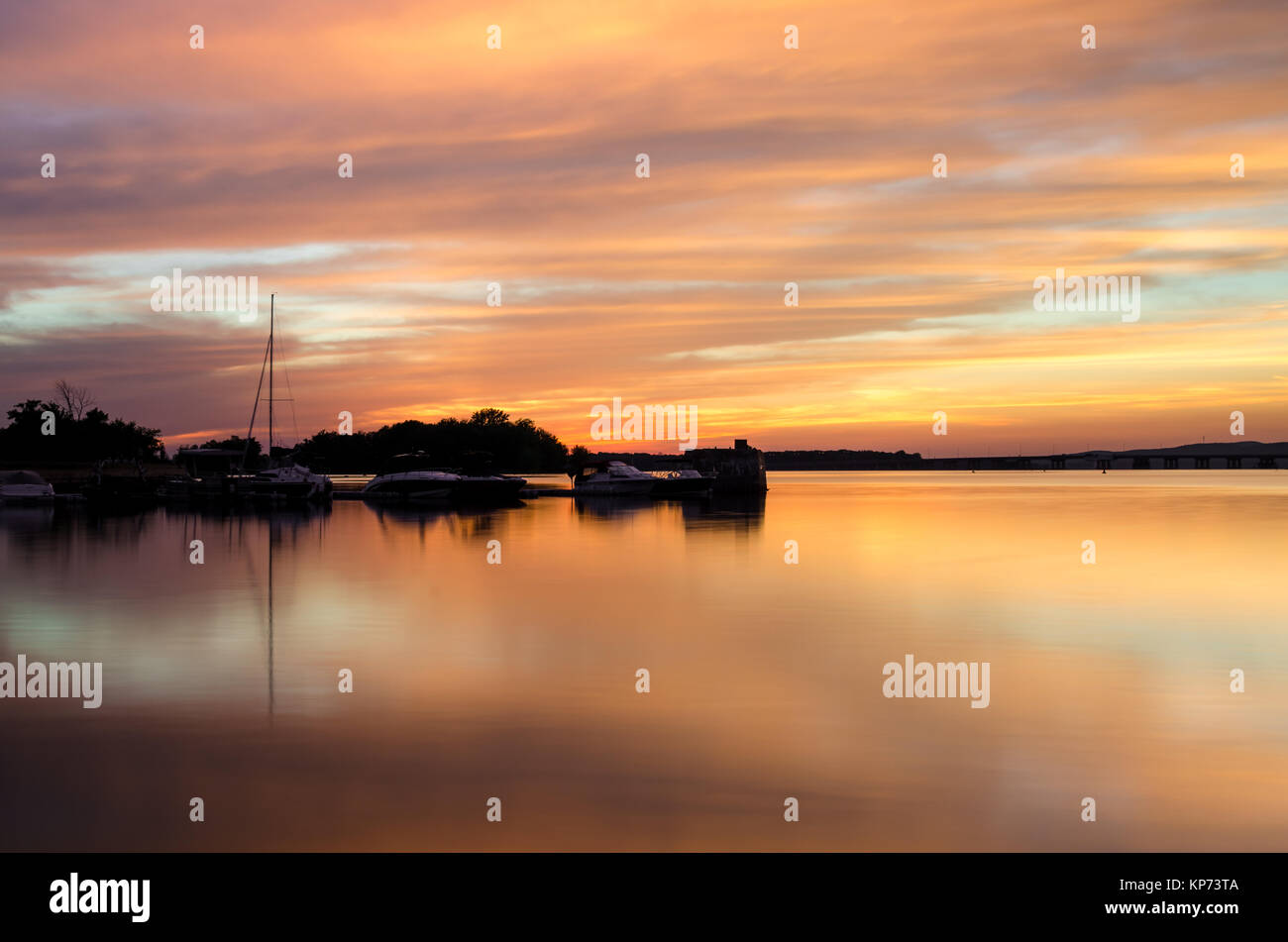 Cielo di tramonto colore riflesso sull'acqua con barche Foto Stock