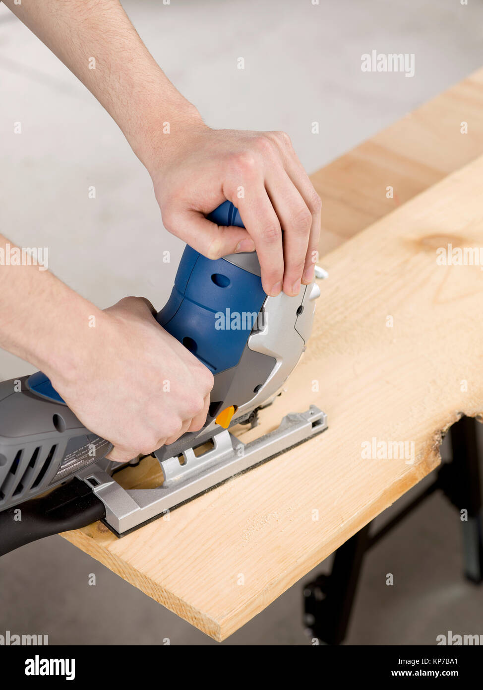 Mano con seghetto alternativo elettrico per tagliare il foglio di legno  Foto stock - Alamy