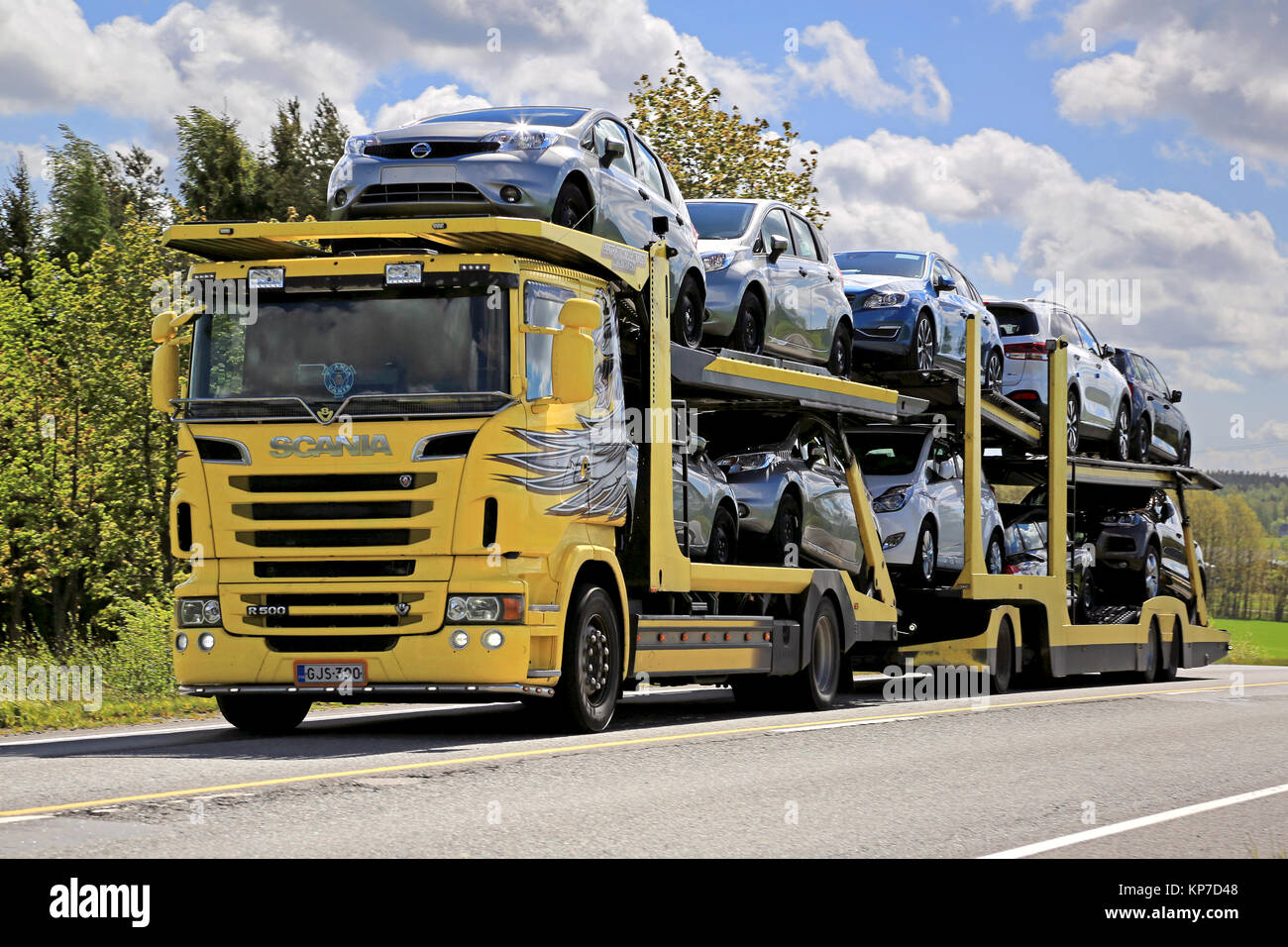 SALO, Finlandia - 31 Maggio 2015: Giallo Scania R500 Carrello traina un carico di nuove vetture. Il finlandese della industria automobilistica stima che un totale di 109.000 nuovo Foto Stock