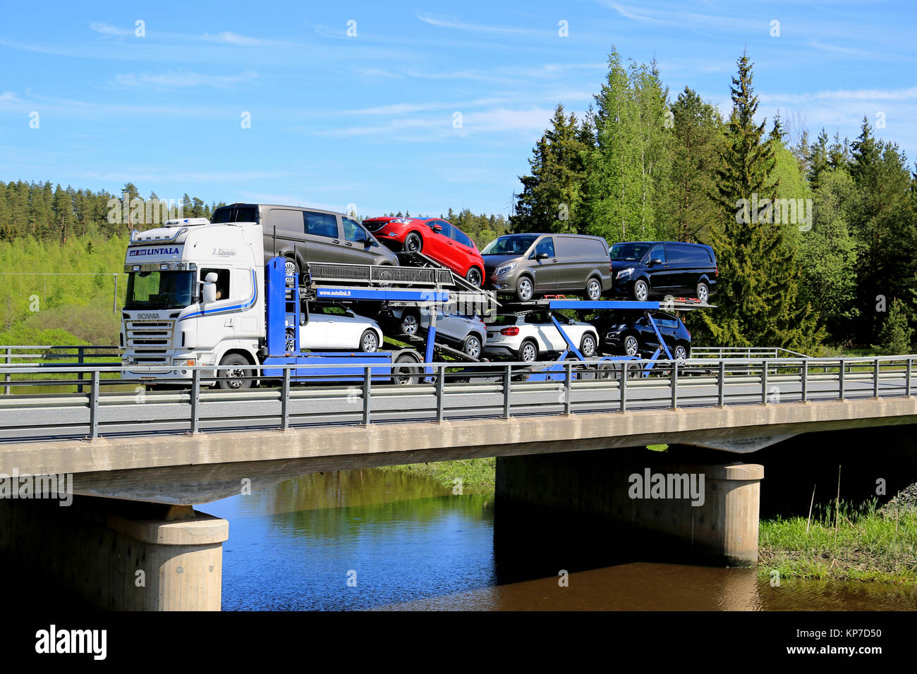 FORSSA, Finlandia - 30 Maggio 2015: Bianco Scania R480 auto veicolo traina un carico di nuove vetture lungo il ponte. Il finlandese della industria automobilistica stima che un Foto Stock