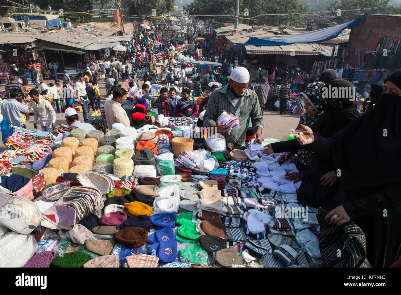 Un distributore in stallo la sua vendita headwear musulmano al mercato del cotone nella vecchia città di Delhi Foto Stock