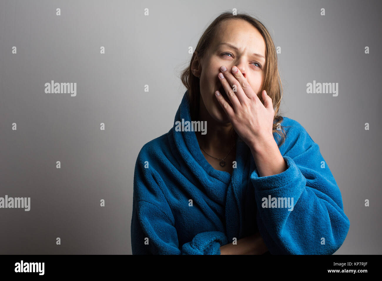 Assonnato giovane donna con la bocca spalancata sbadigli Foto Stock