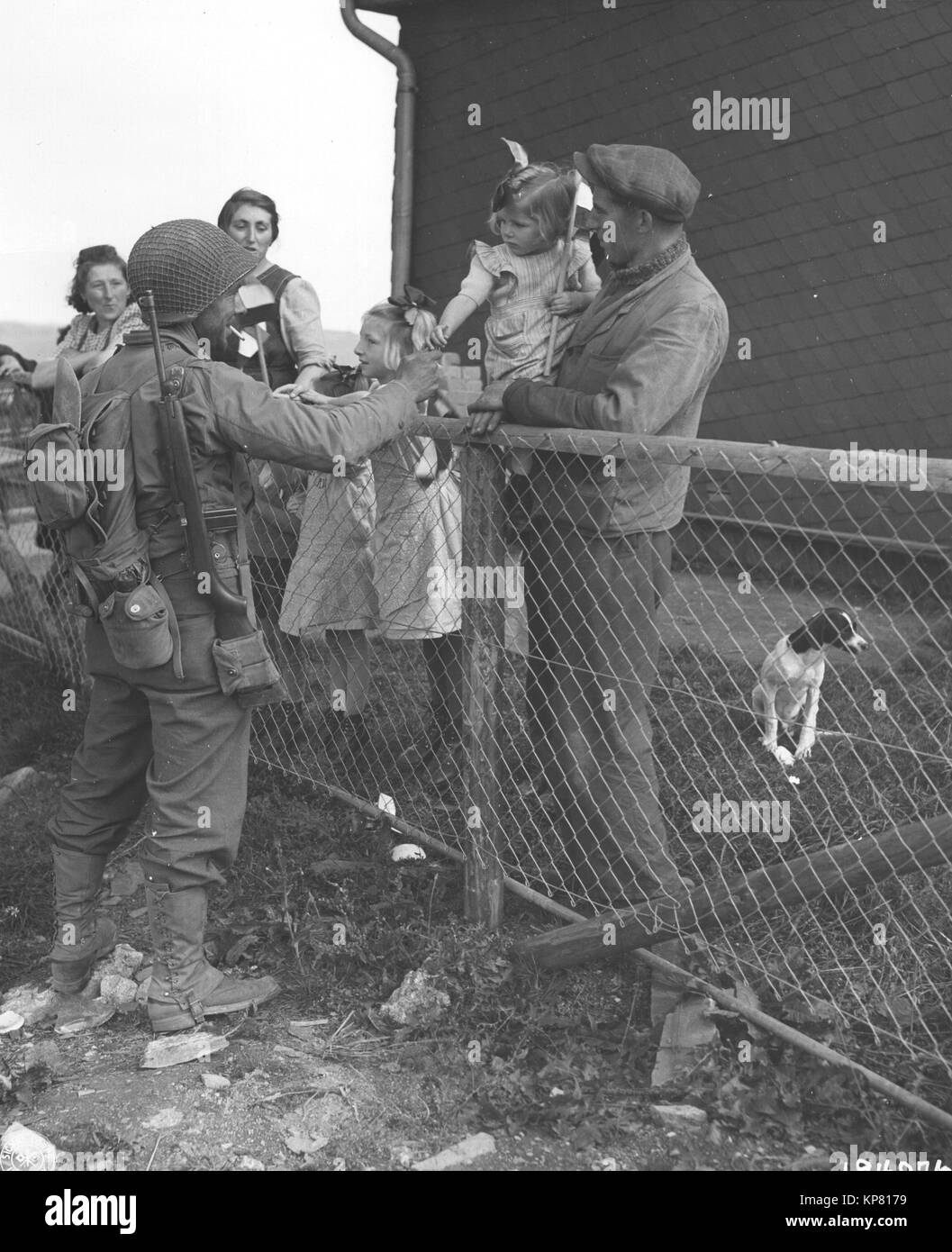 9 11 1944 Pvt. Eugene V. Webber, a sinistra di San Leandre, California, un membro del secondo battaglione, 110th reggimento, ventottesima divisione, mani una bambina di un bastone di gomma da masticare in città di Asselbourn, Lussemburgo Foto Stock