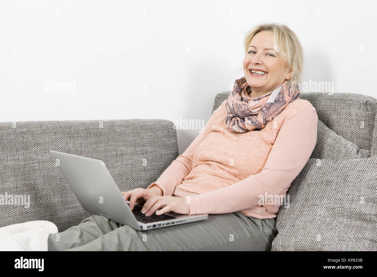Donna con notebook sul divano Foto Stock