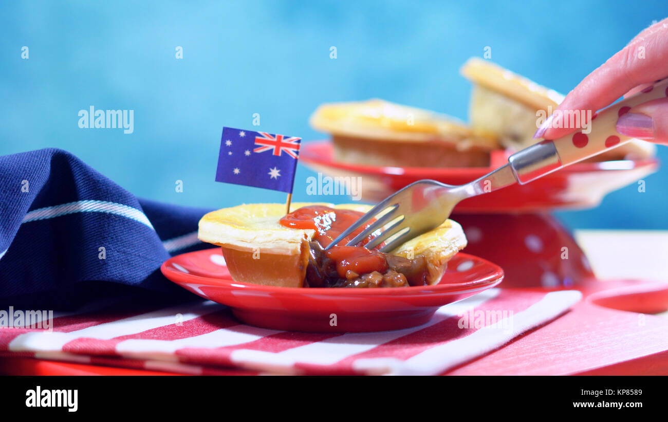 Tradizionale australiana pasticci di carne per l'Australia o Anzac Day holiday party cibo, in rosso, bianco e blu impostazione tabella. Foto Stock