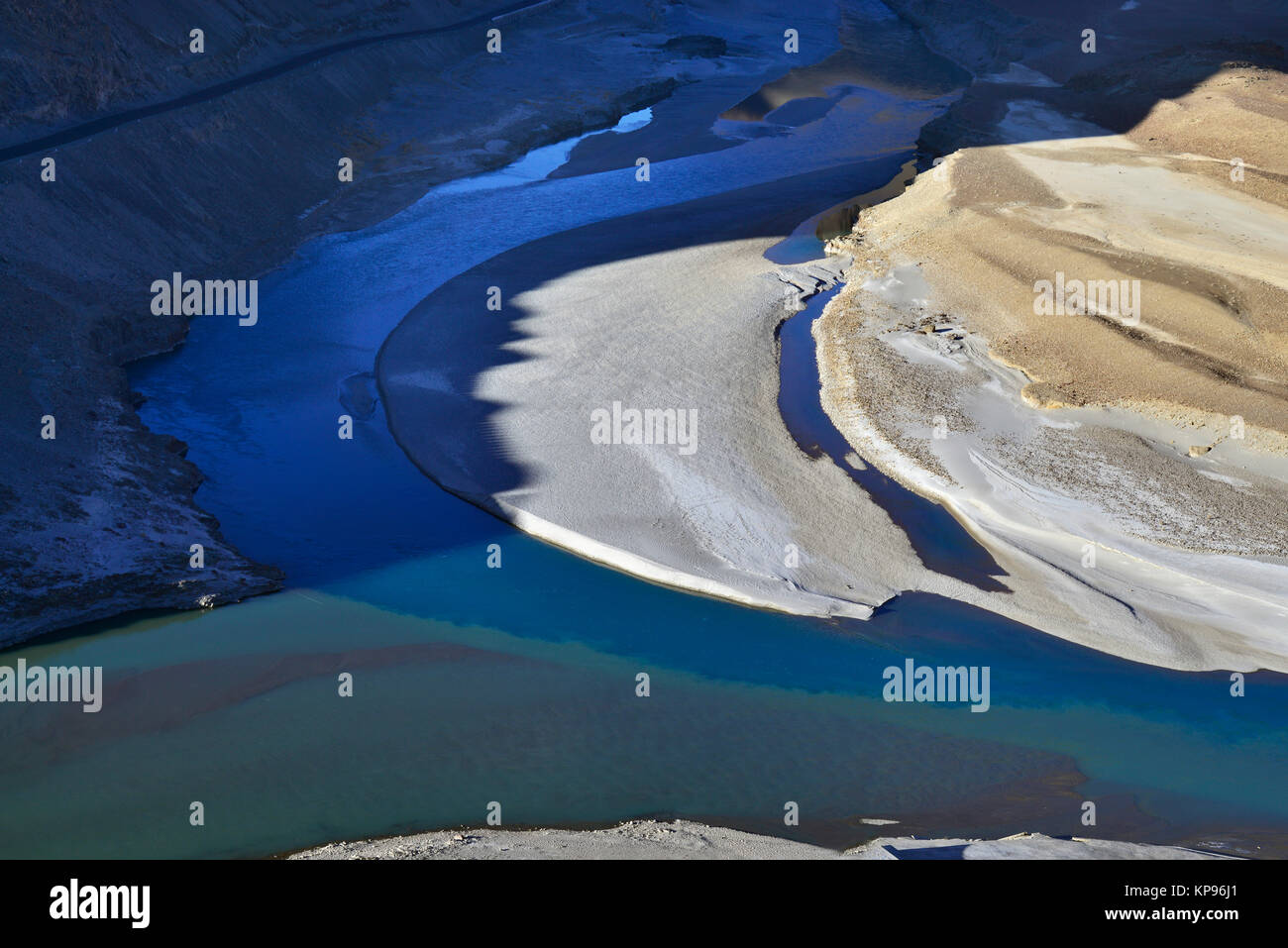 La confluenza del fiume Indo e Zanskar, due flussi di diversi colori si fondono, di un colore giallo brillante isola di sabbia di fiume, Ladakh. Foto Stock