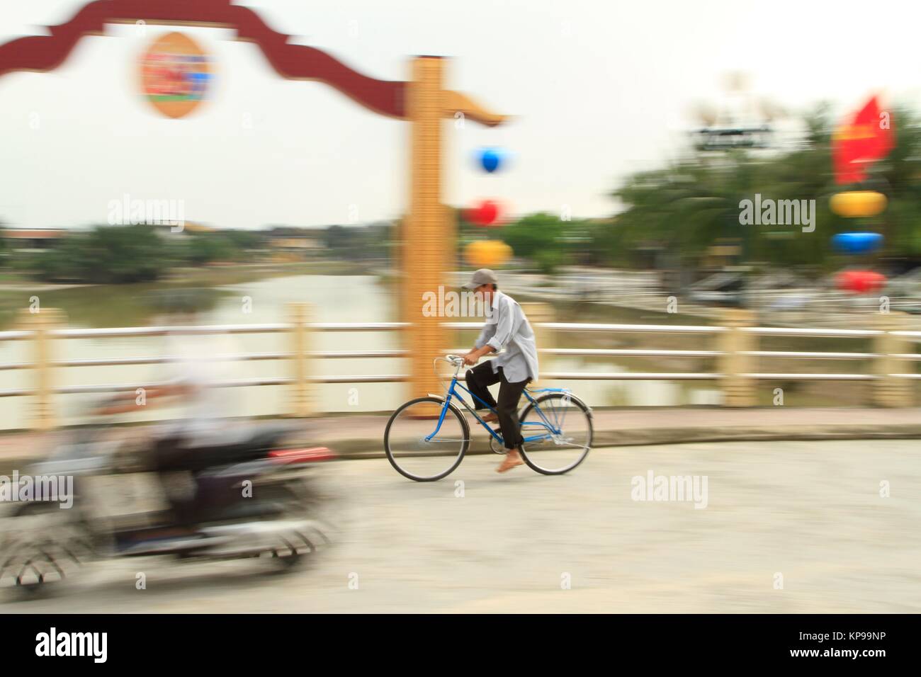 Bike commuter attraversando il ponte di Hoi An, Vietnam Foto Stock