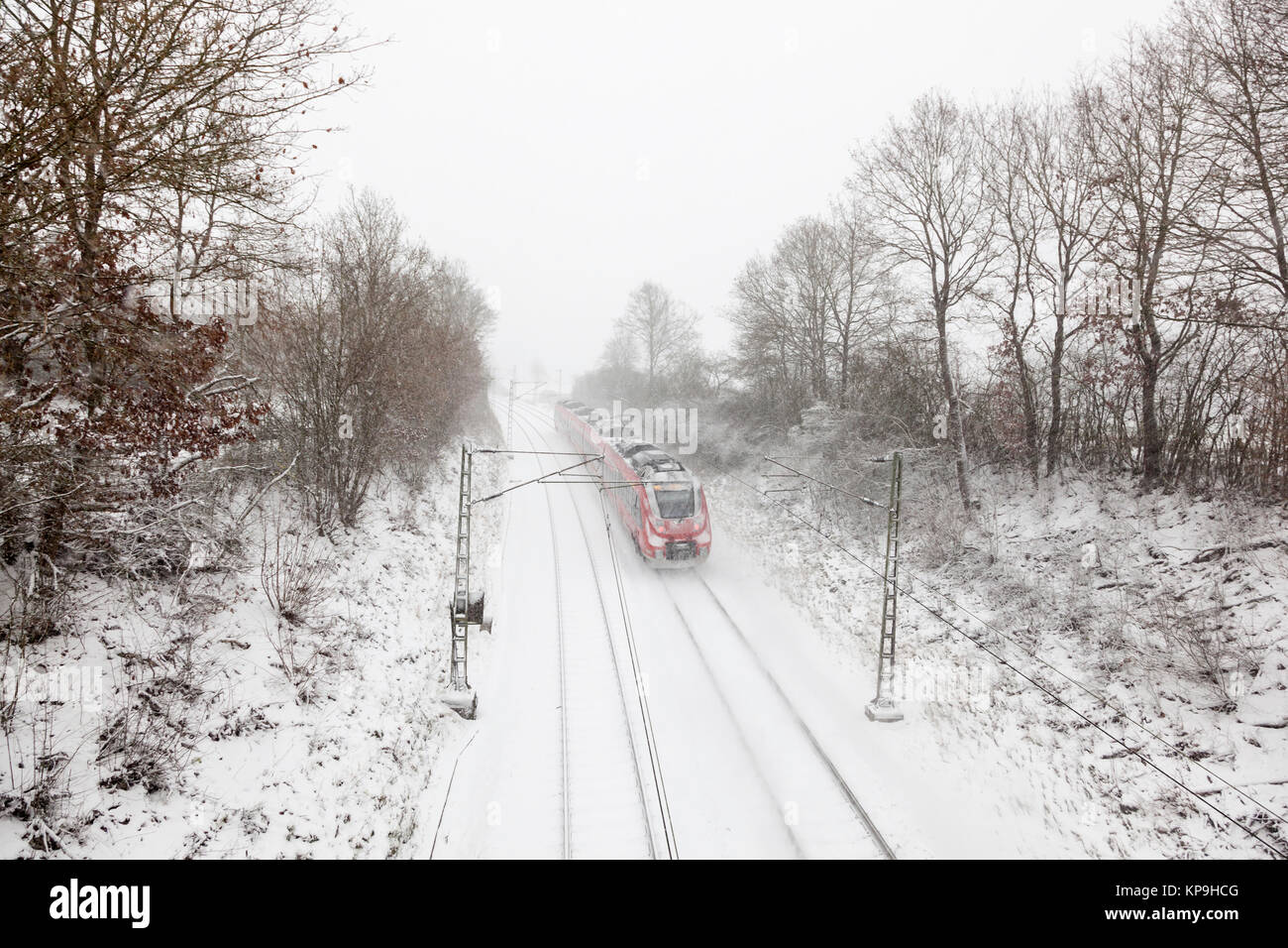 Treni passeggeri passando da durante una nevicata in inverno Foto Stock