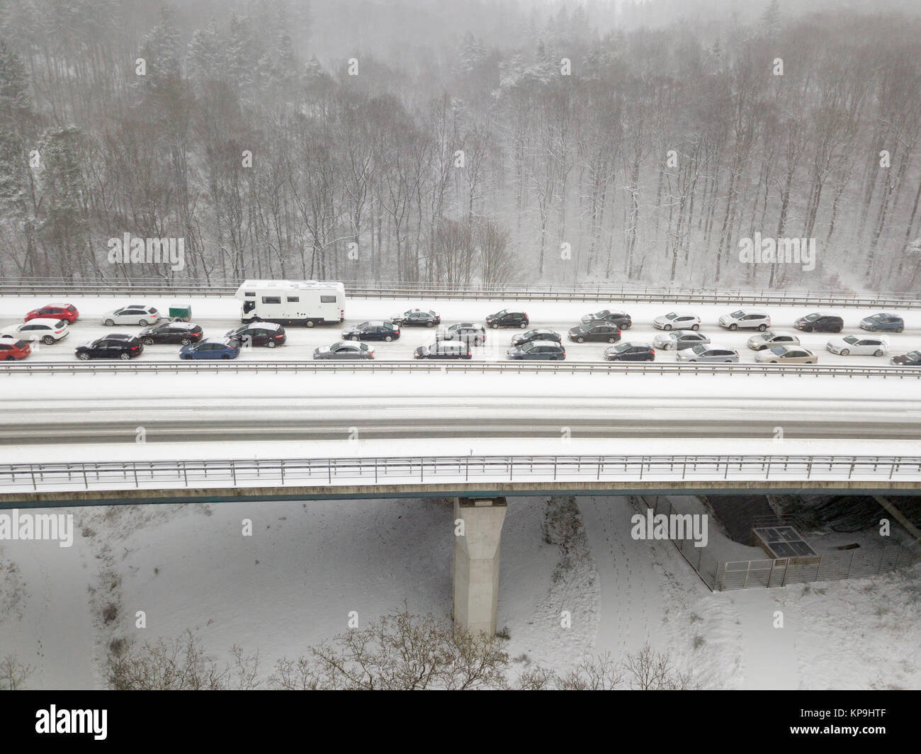 Auto su un ponte autostradale durante una nevicata in inverno Foto Stock