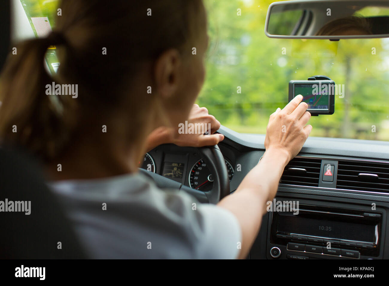 Giovane donna alla guida la sua automobile, sul suo modo a casa dal lavoro Foto Stock