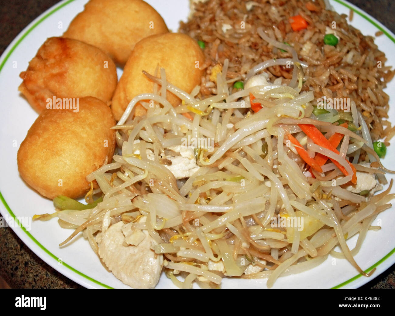 Cinese di estrarre il cibo su una piastra. Deep Fried Chicken sfere, pollo chop suey pollo e riso saltato con verdure Foto Stock