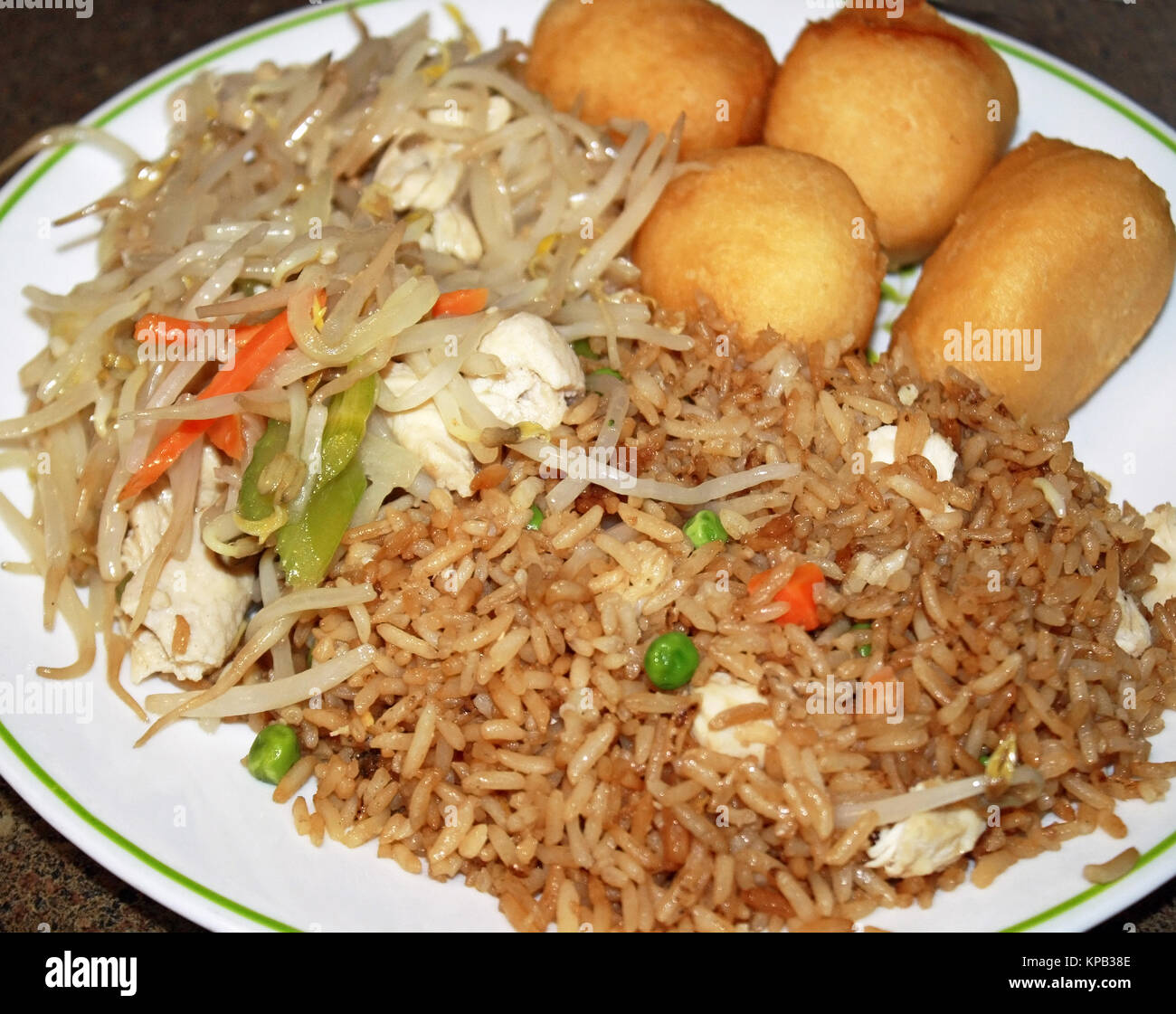 Cinese di estrarre il cibo su una piastra. Deep Fried Chicken sfere, pollo chop suey pollo e riso saltato con verdure Foto Stock