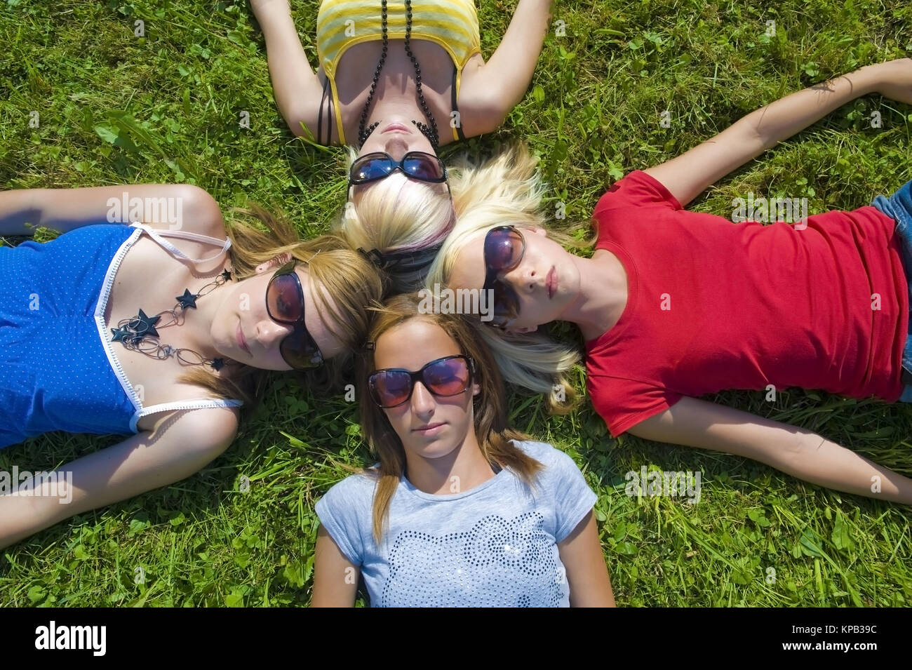 Modello di rilascio, Symbolbild Freundeskreis, Jugendliche Maedchen liegen Kopf un Kopf in der Wiese - simbolico per un circolo di amici Foto Stock