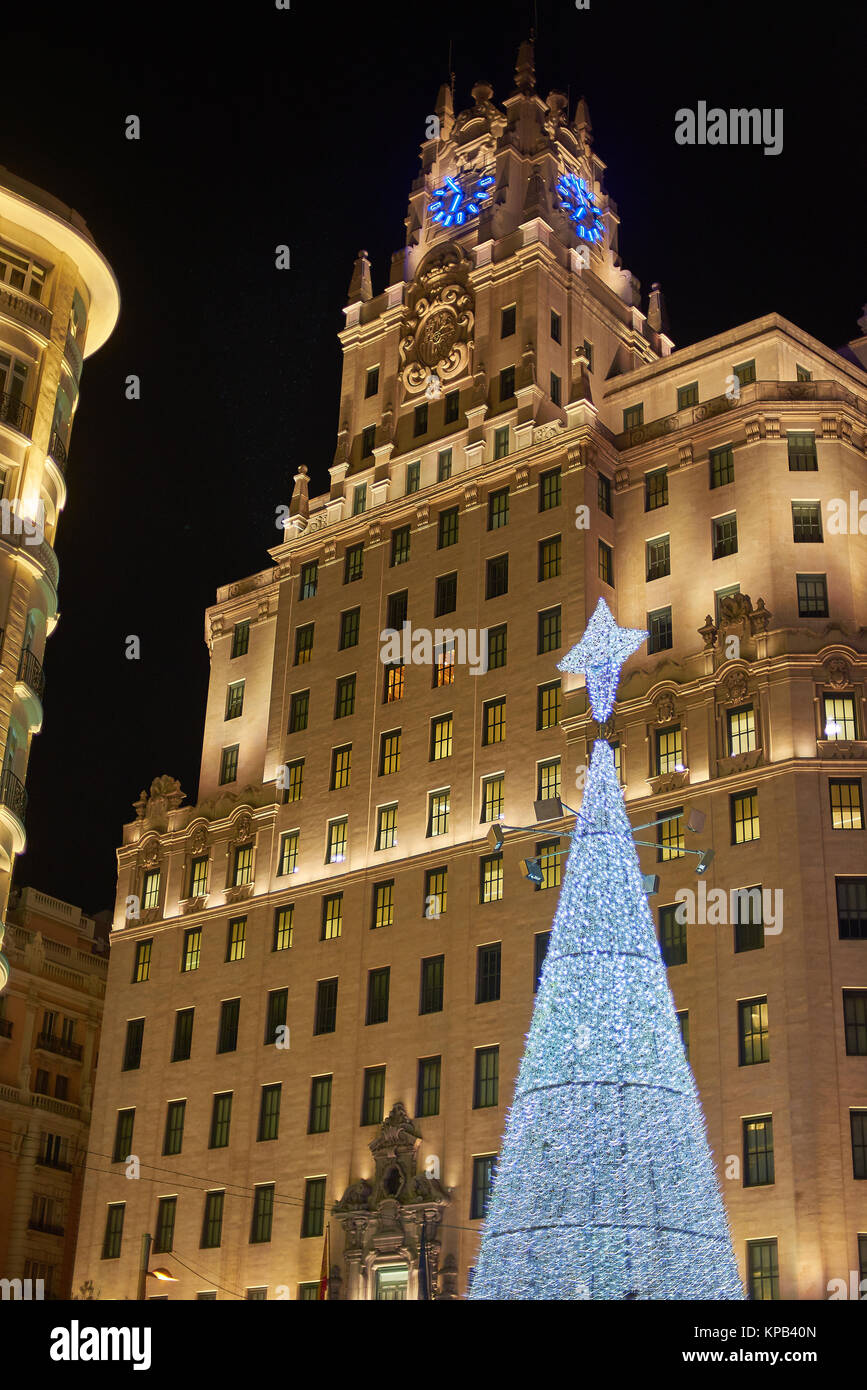 Edificio di Telefonica in Gran Via di Madrid con un lucido albero di natale in primo piano. Madrid, Spagna. Foto Stock