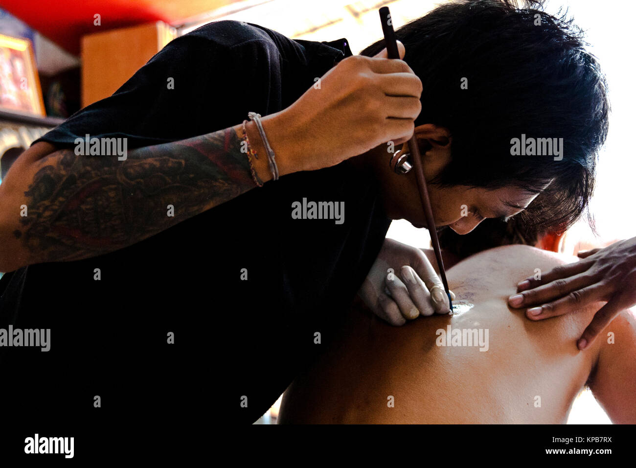 Tourist ottenendo un tradizionale Thai tatuaggio in un salotto in Koh Phi Phi Island Foto Stock