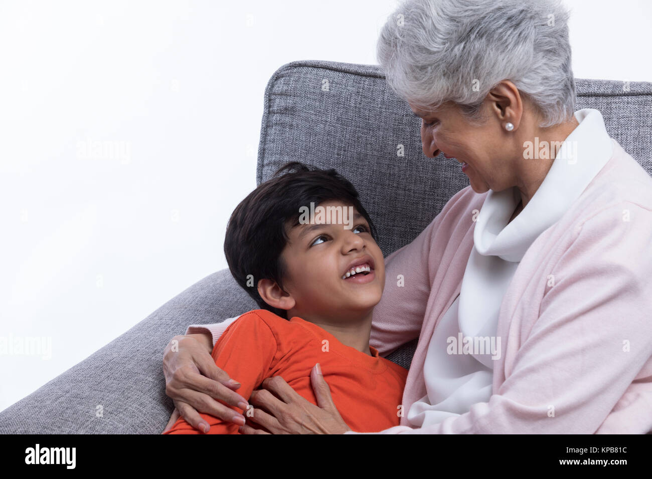 Nonna e nipote seduti insieme sul divano divertendosi Foto Stock